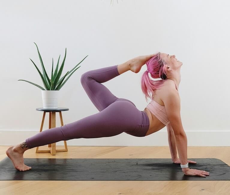 Female doing scorpio pose to increase muscle strength