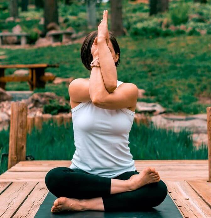 girl doing eagle arm yoga pose